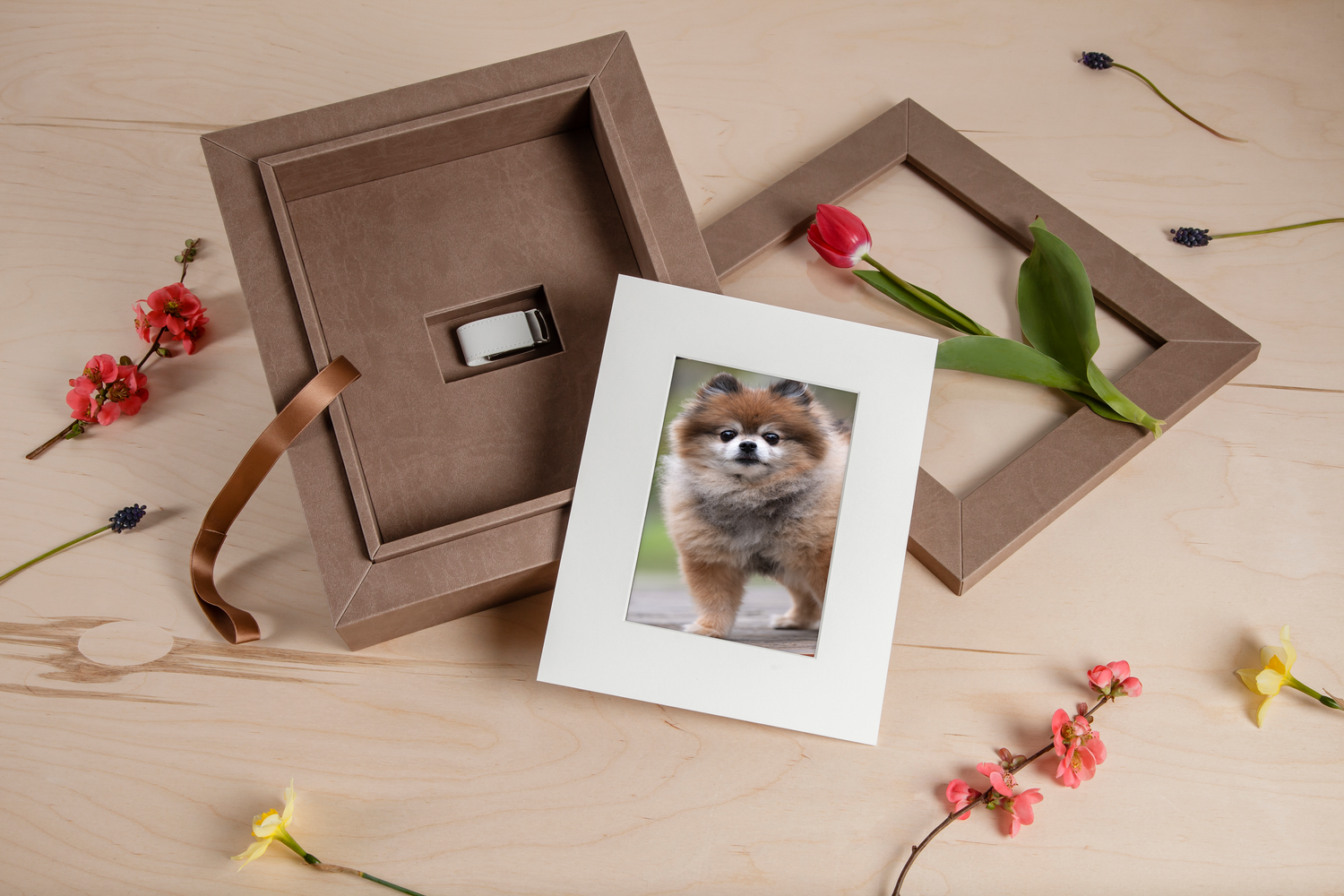 Flat lay of photo prints and decorative elements on beige surface.