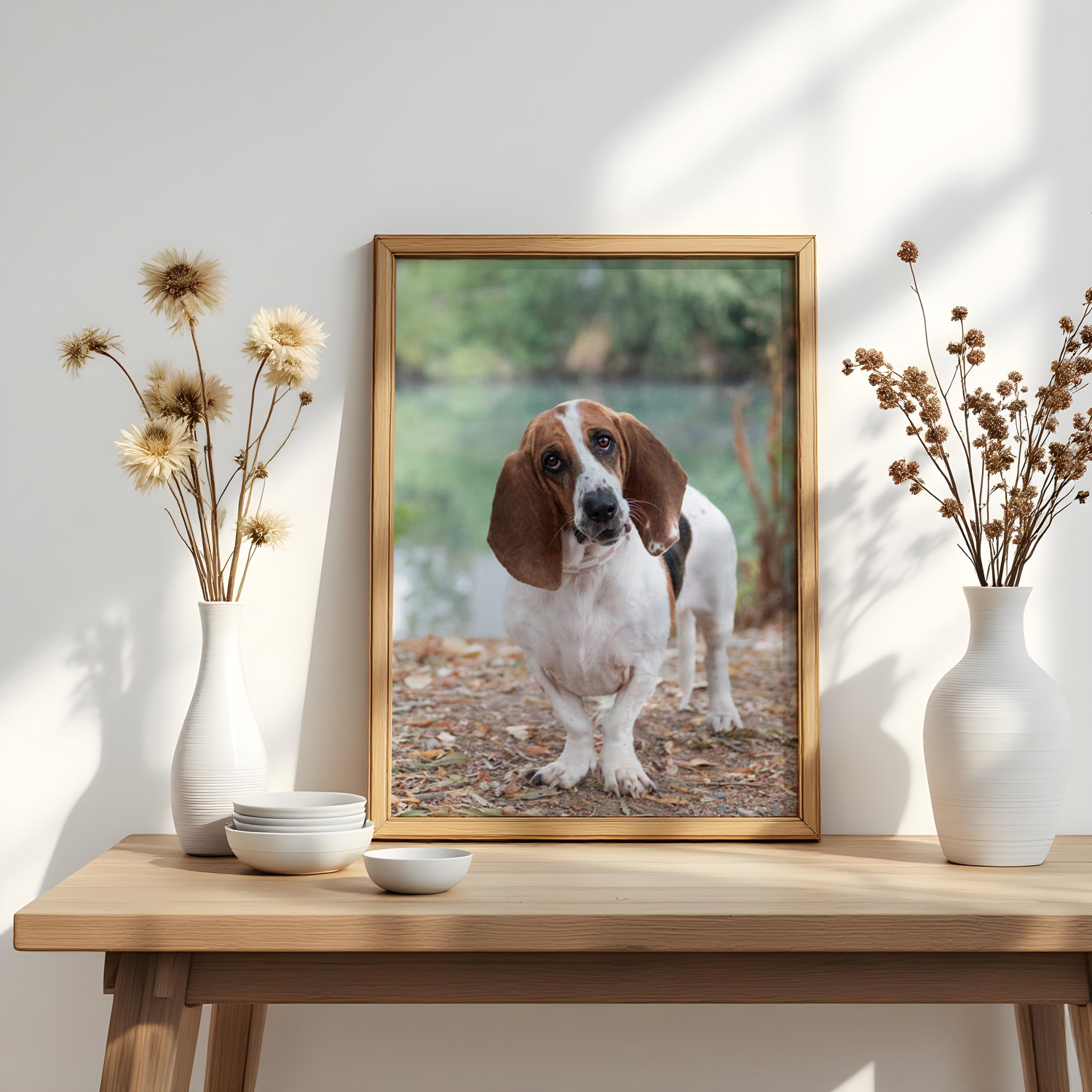 Minimalist shelf styling with white vases and framed dog photographs in natural light.