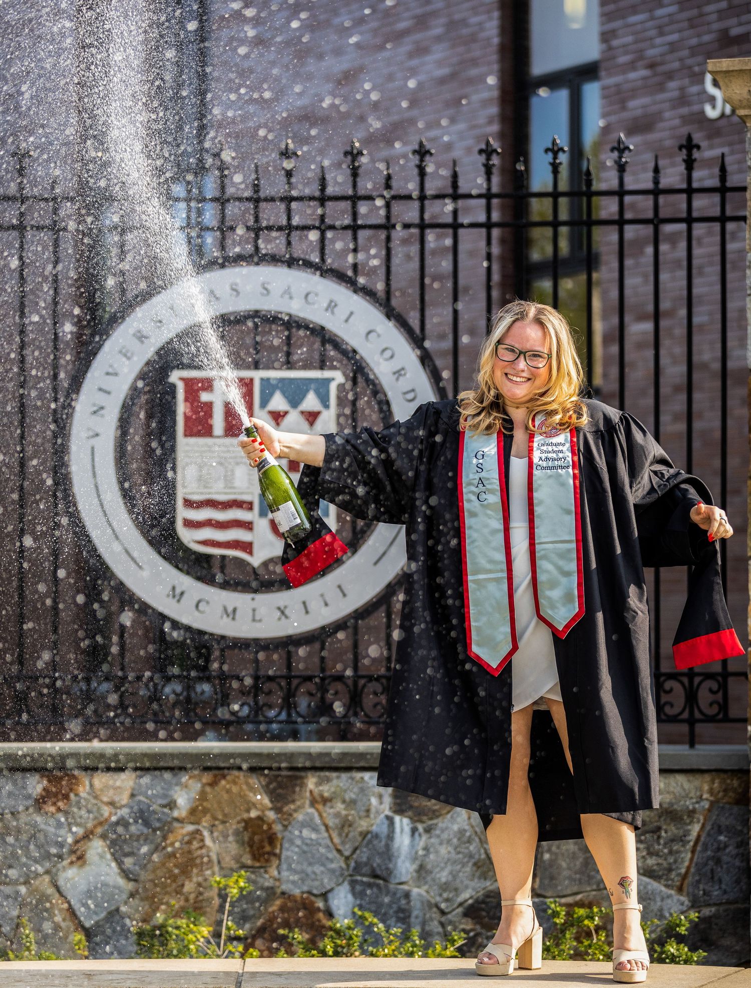 Graduate spraying champange at Sacred Heart University.