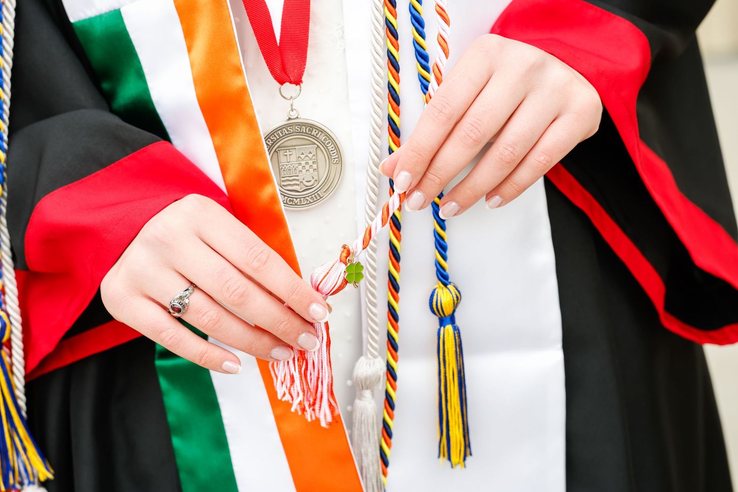 Close-up detail of graduation stoles and tassels in red, white and green colors.