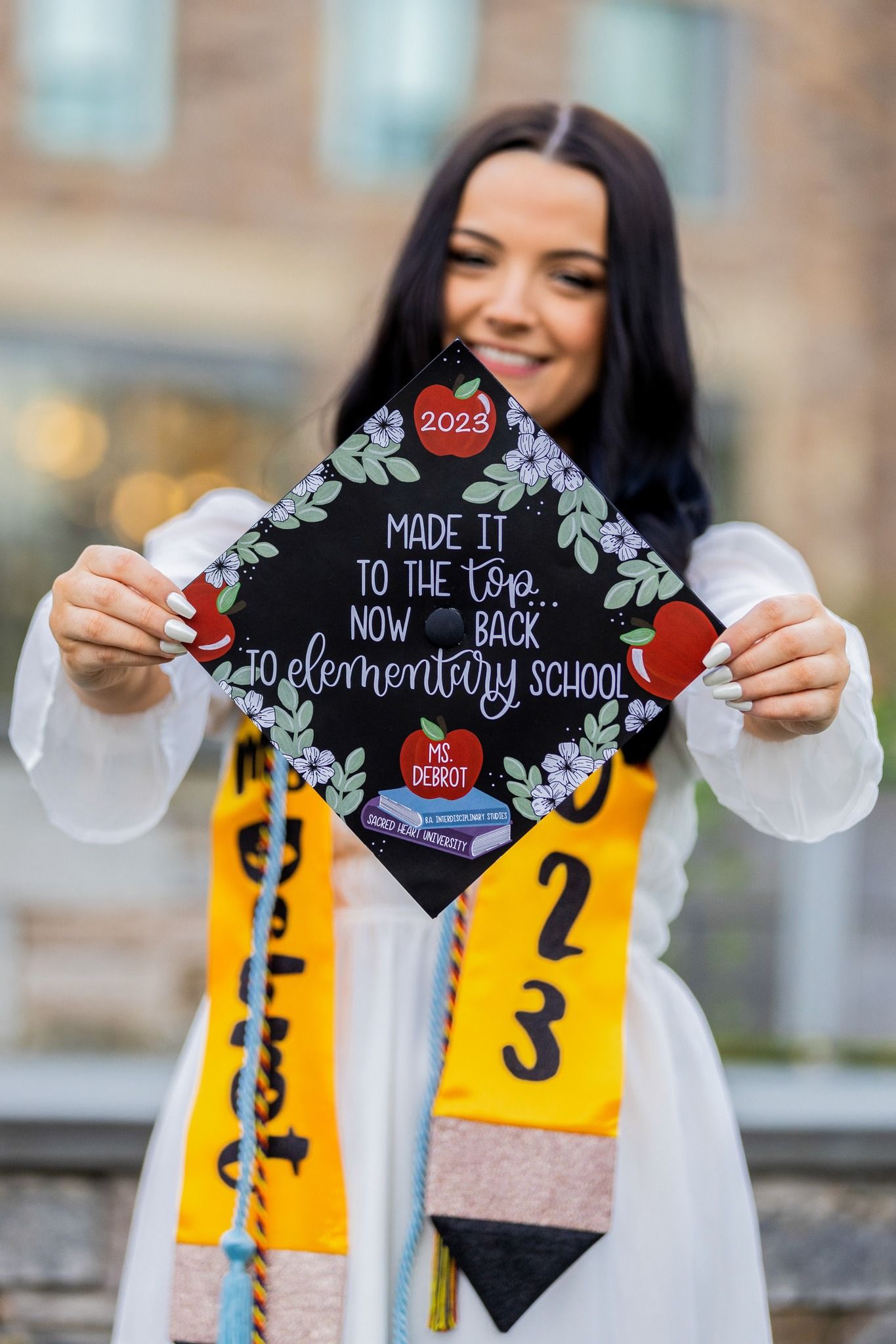 Decorated graduation cap features ornate designs and inspirational message in white against black background.