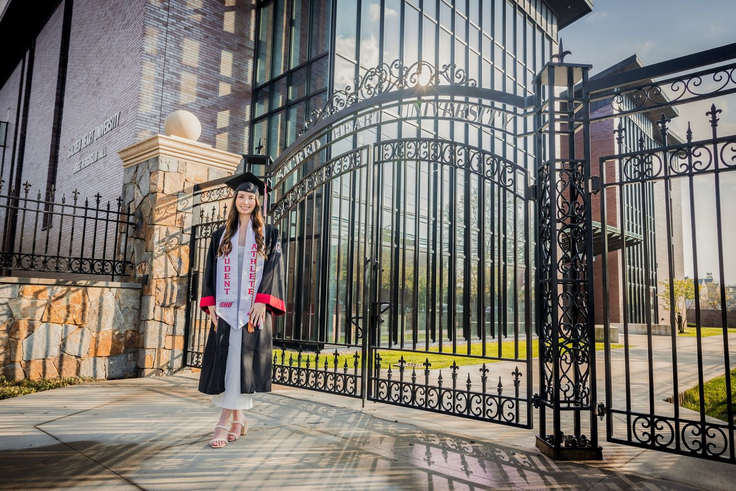 Ornate wrought iron gates frame an elegant building entrance with curved architectural details.
