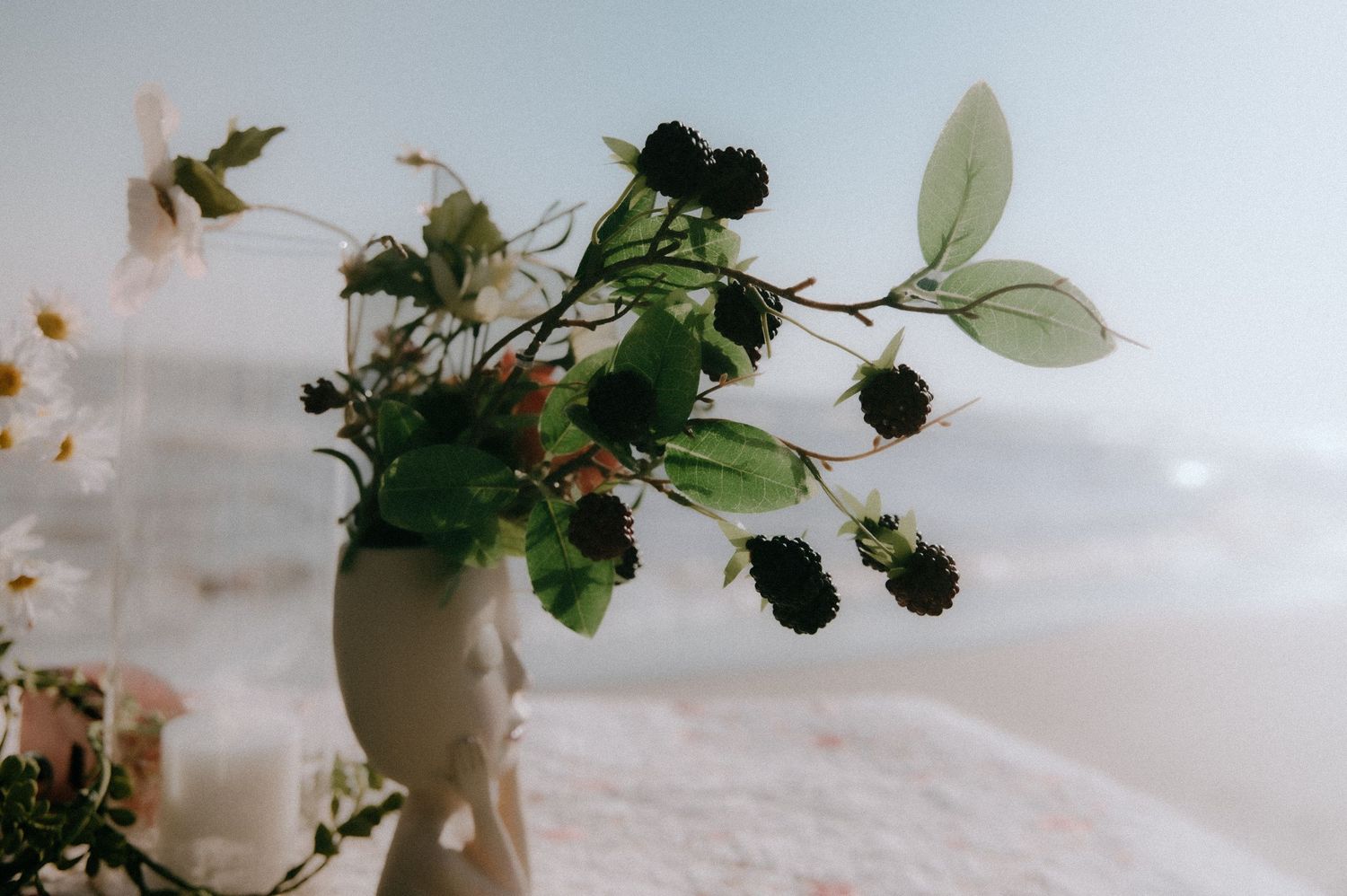White and green floral arrangements with delicate blooms displayed in various decorative containers.