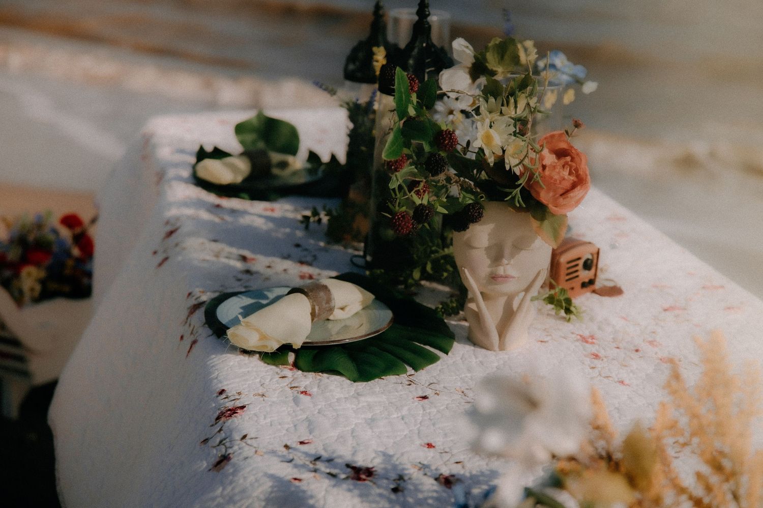 Floral table arrangement with decorative elements displayed on a white surface with vintage styling.
