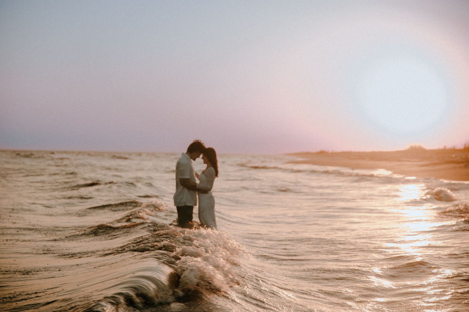 Scenic beach sunset over the ocean with warm golden light reflecting on the water.
