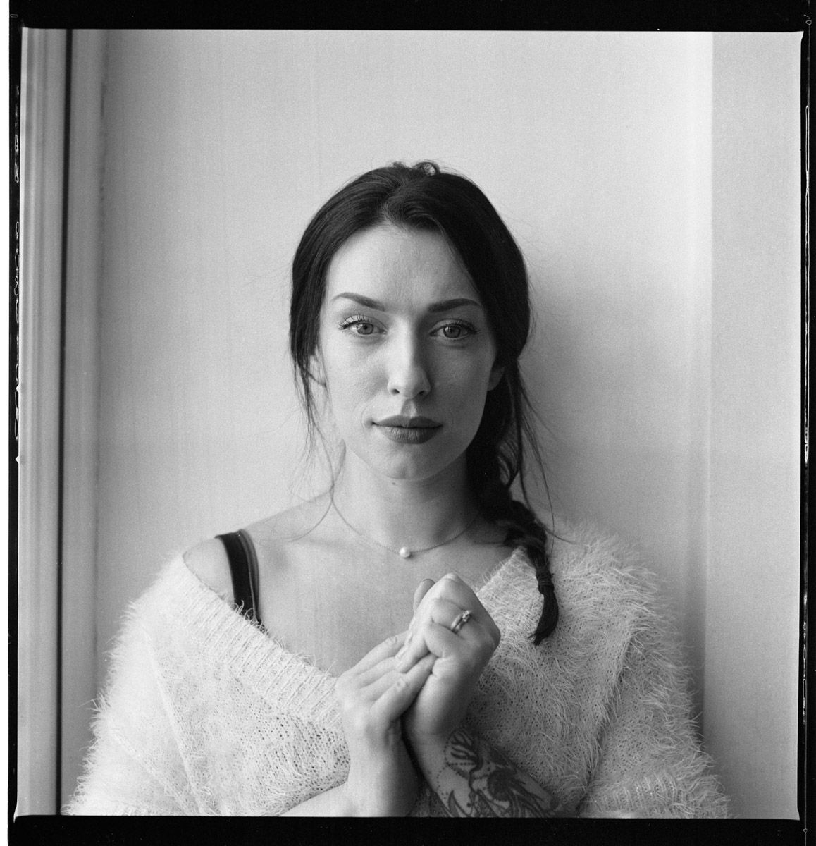Person sitting for relaxed black and white lifestyle portrait.