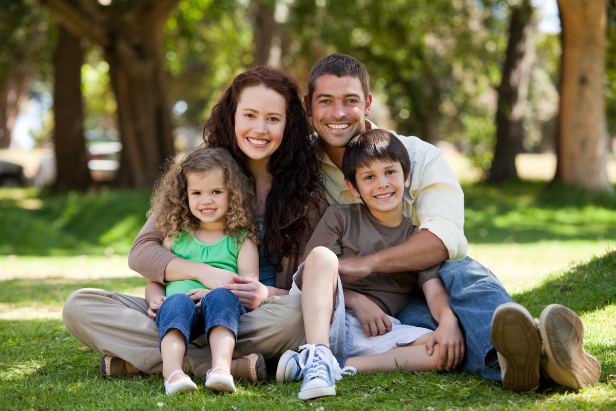 Smiling family of four in natural light outdoors in Cork, Ireland.