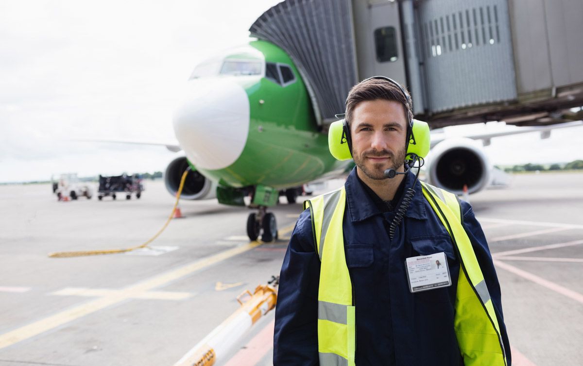 Exterior of commercial aircraft on tarmac in Cork with ground operation crew looking on.