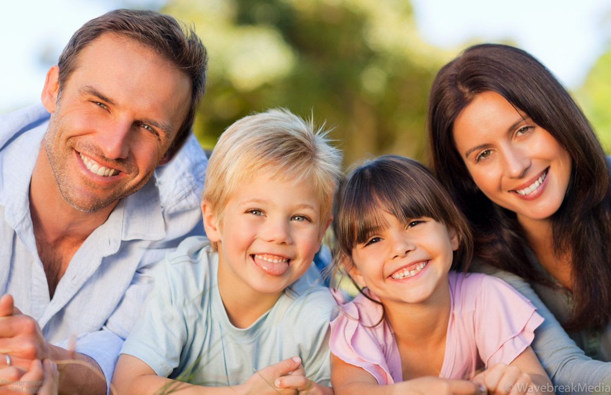 Family of four posed for professional outdoor portrait.