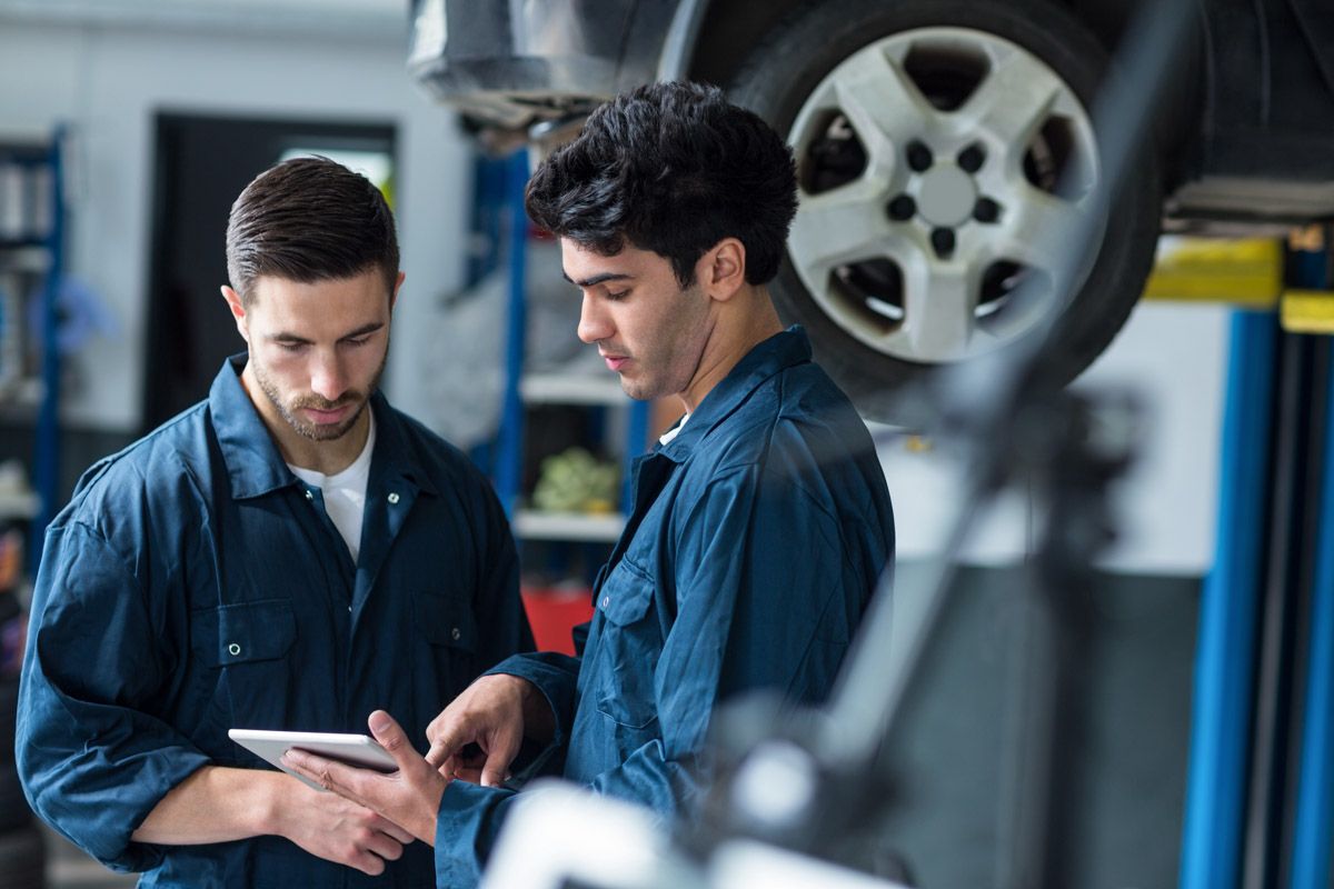 Automotive professional inspecting engine components.