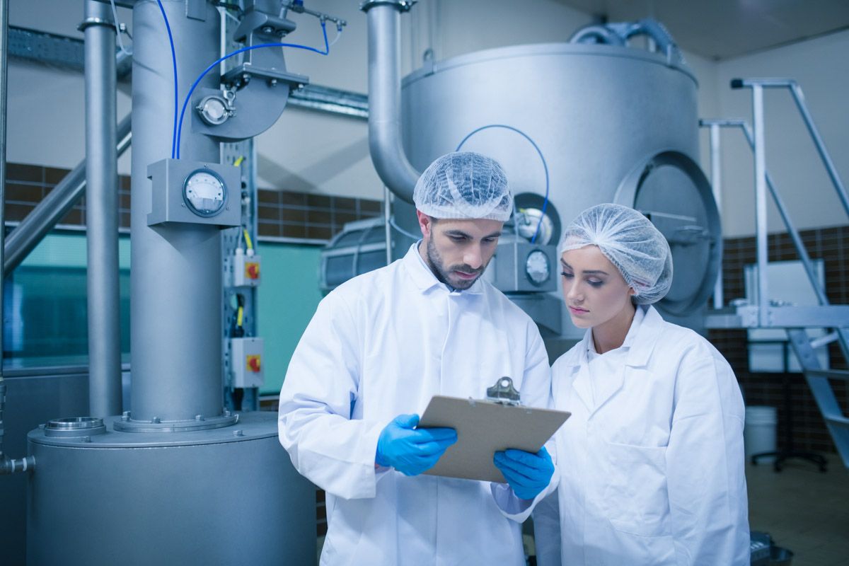 Two employees discussing production process in lab environment.