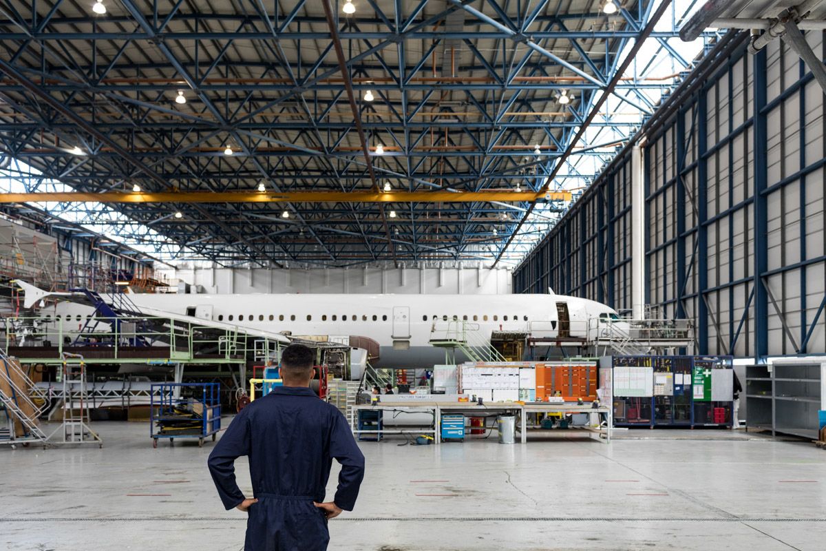 Maintenance team inspecting airplane exterior in Hanger.