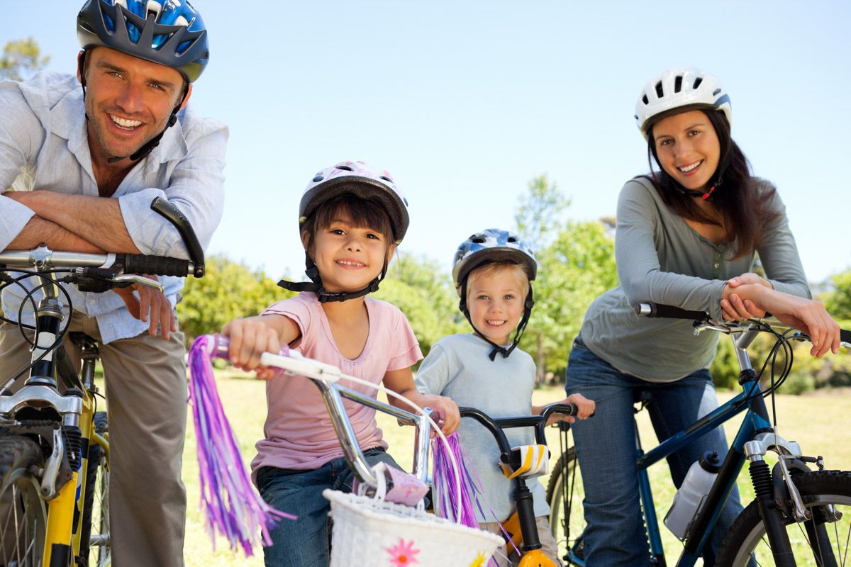 Photo of Active family outdoors cycling together.