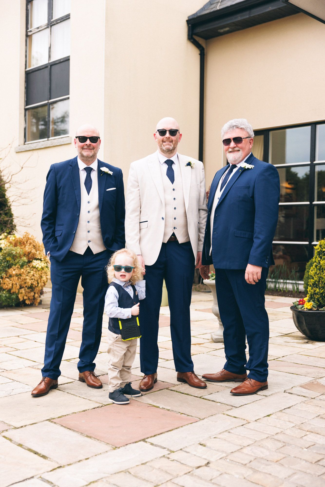 Photo of groomsmen wearing sunglasses before wedding.