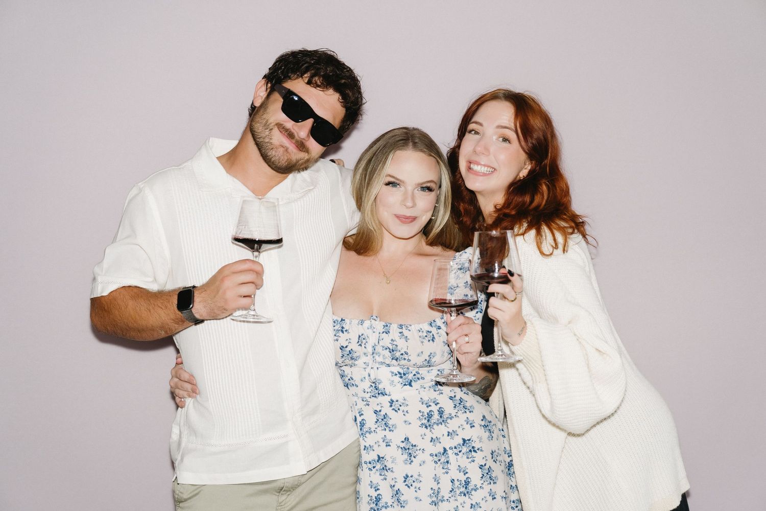 Group poses with drinks in a casual studio photoshoot setting.
