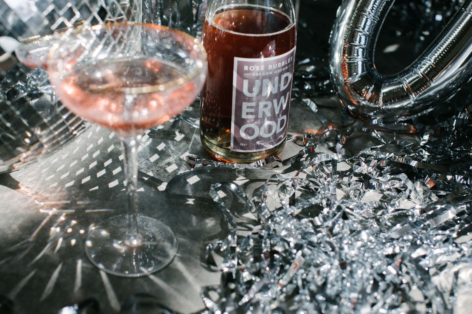 Crystal wine glasses sparkle against a black backdrop with water droplets creating an elegant and mesmerizing pattern.