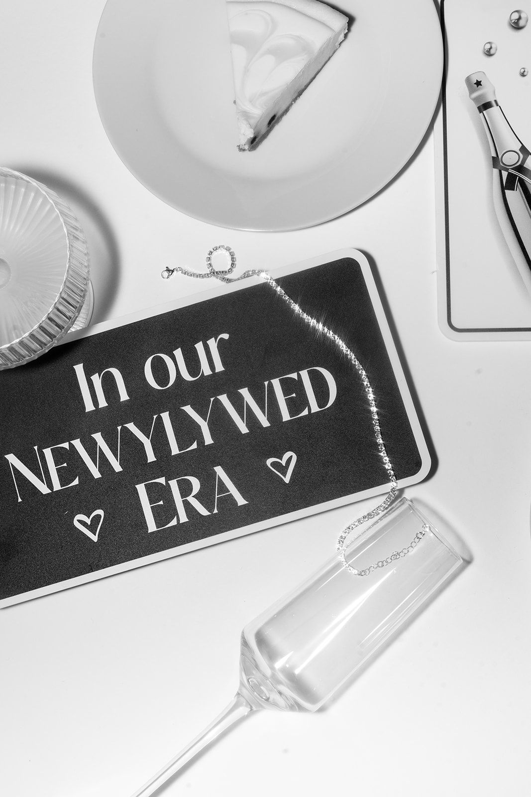 Black and white photograph showing decorative plates and text signs with hearts in a clean minimalist composition.