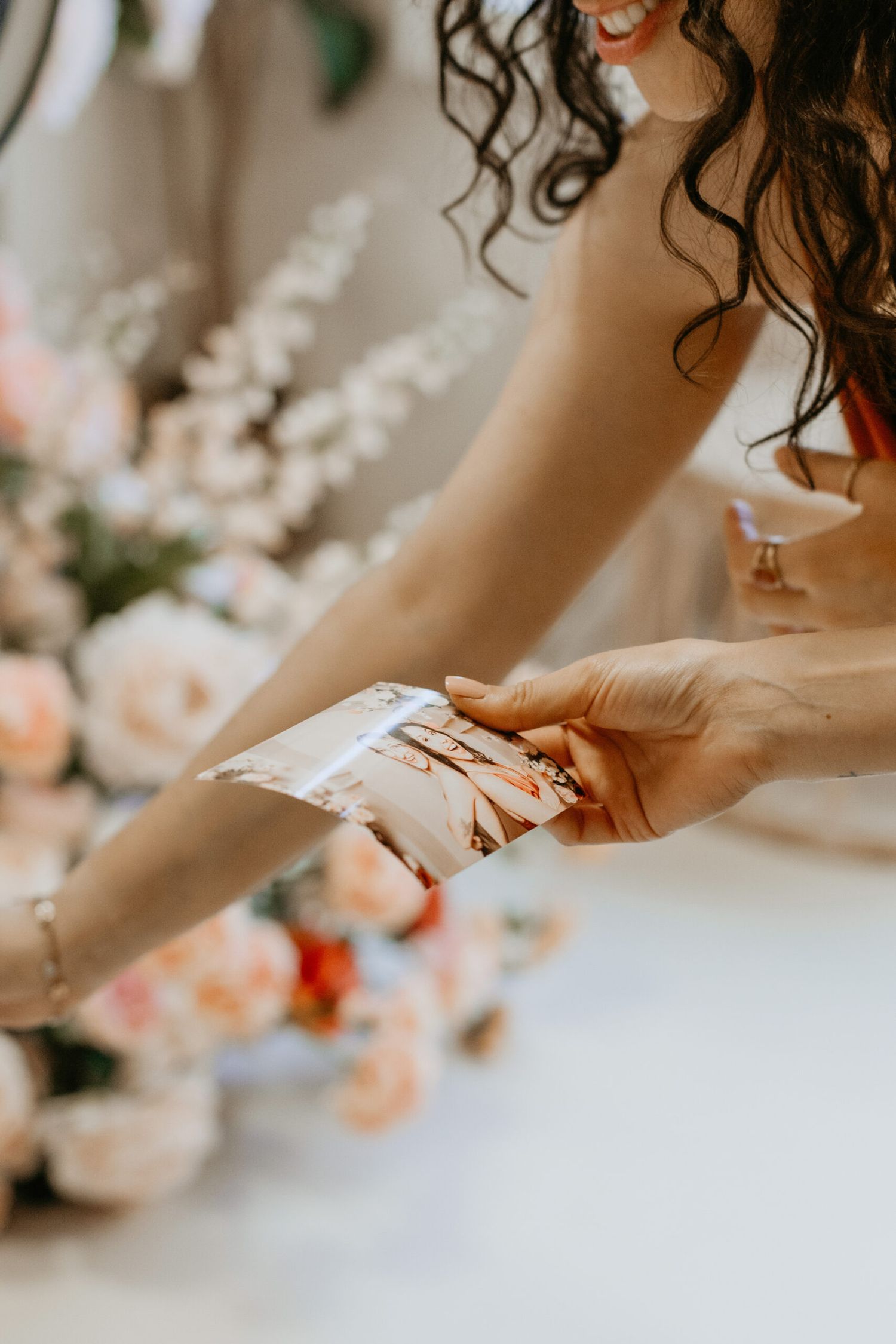 Delicate hands arranging flowers with soft focus floral background.