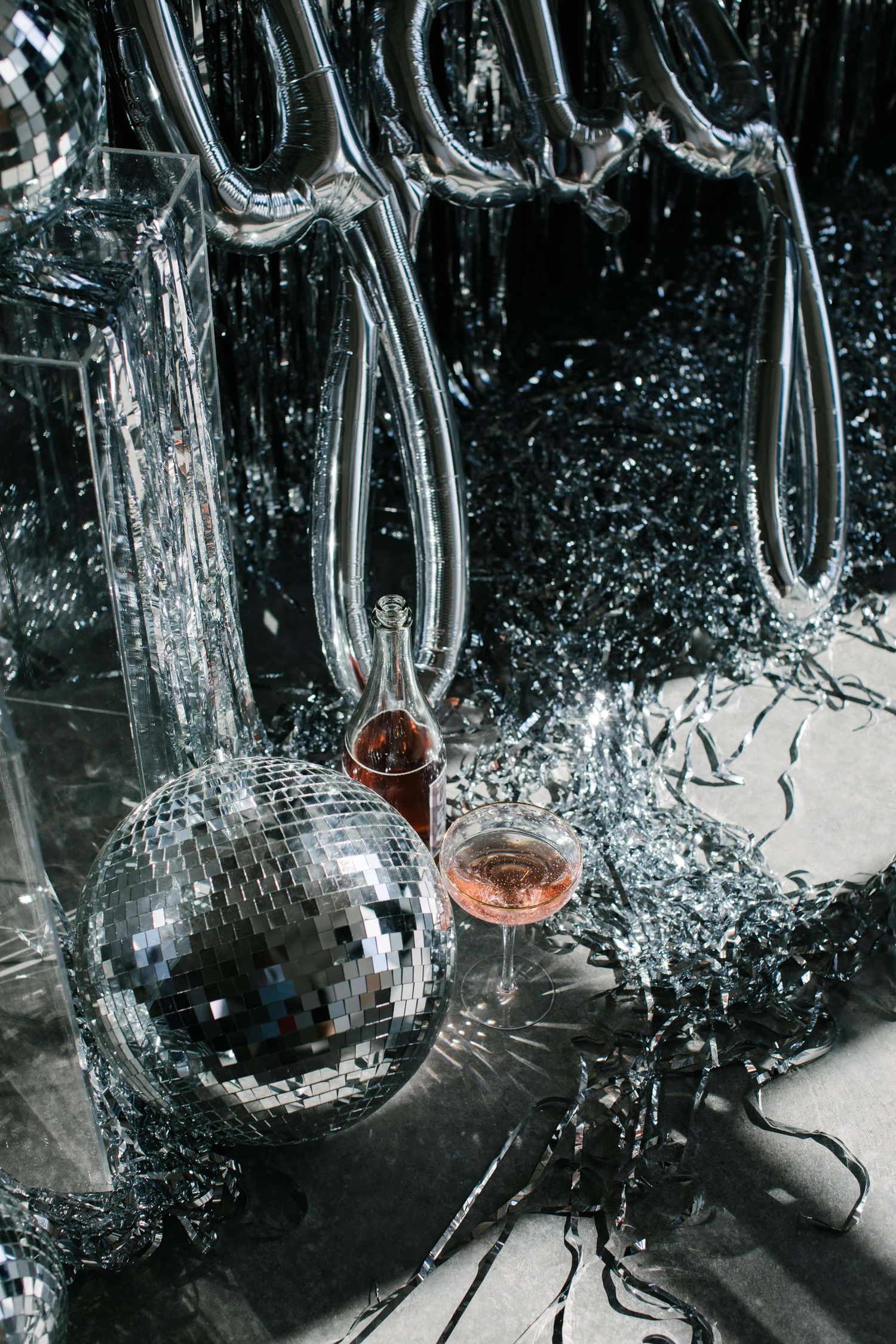 Shattered disco ball with glass fragments exploding in dramatic black and white photography.