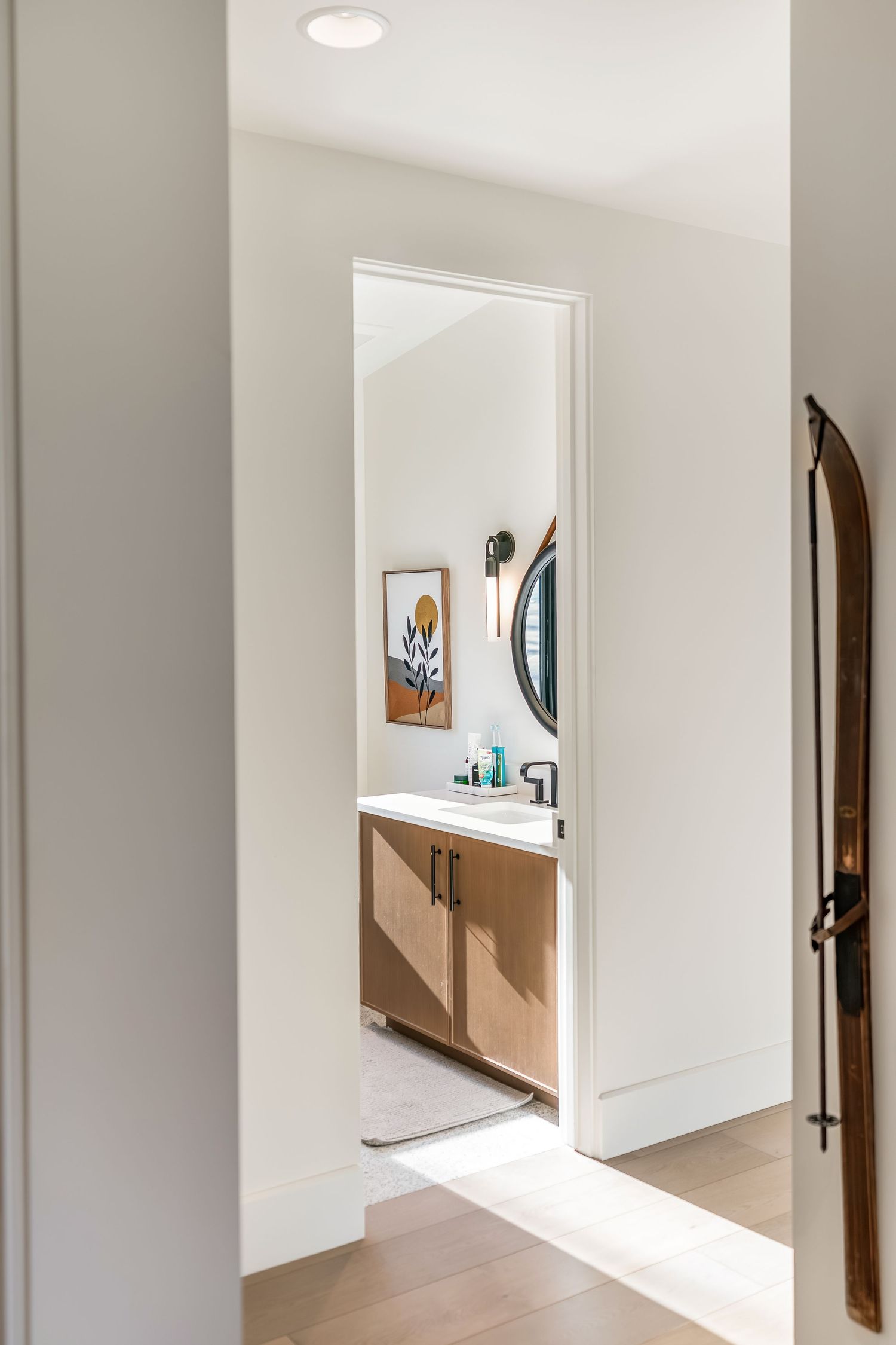 Minimalist white hallway interior with curved walls and wooden accents showcases modern architectural design elements.