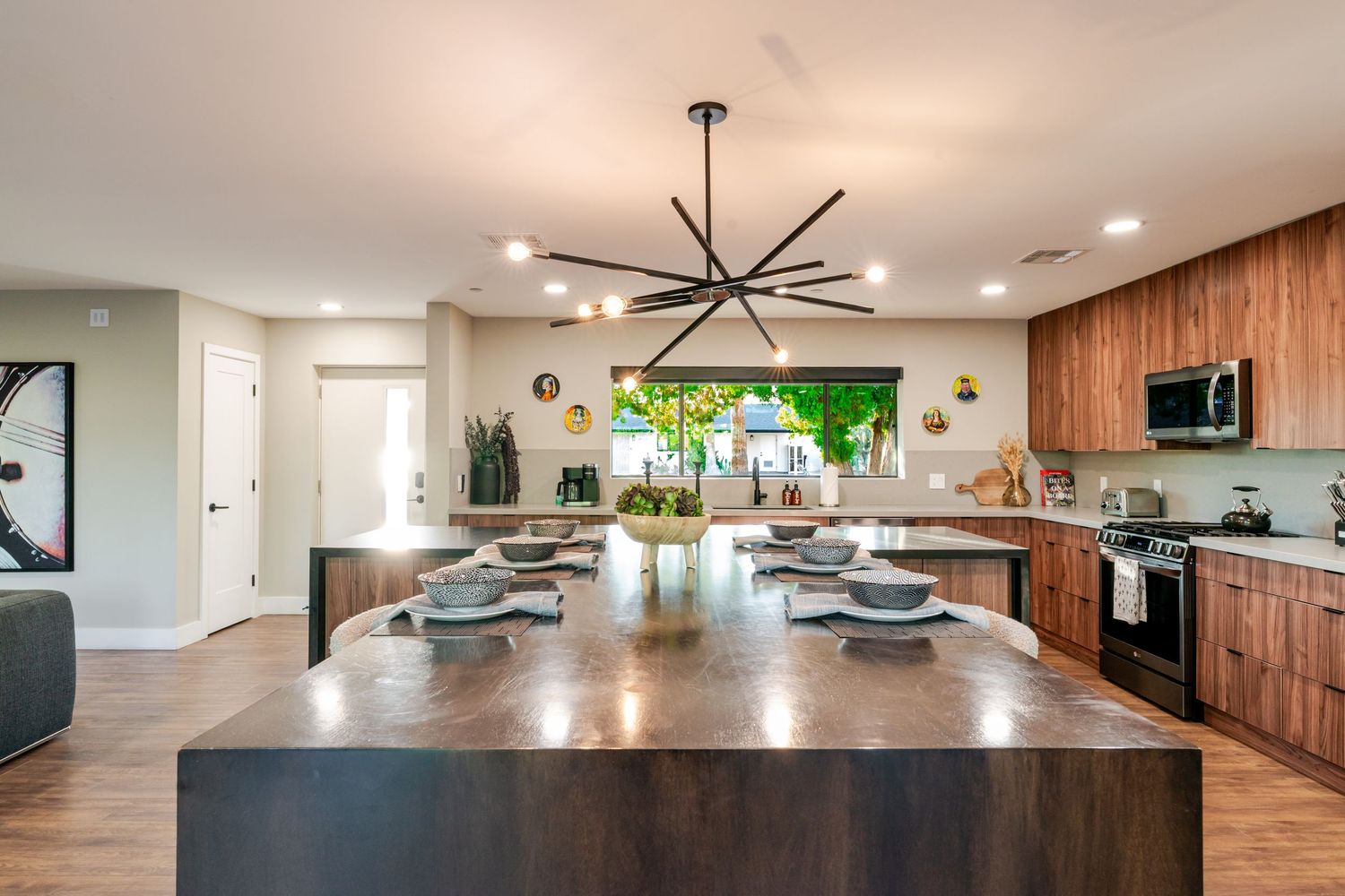 Modern kitchen with wood cabinetry, expansive island, and pendant lighting in an open floor plan design.