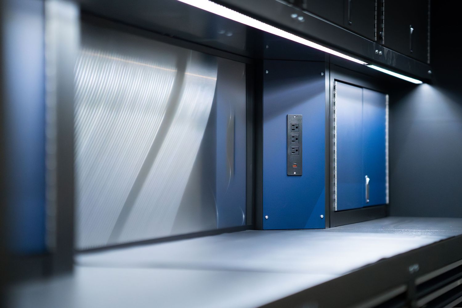 Modern automotive showroom with clean lines and dramatic blue LED lighting strips.