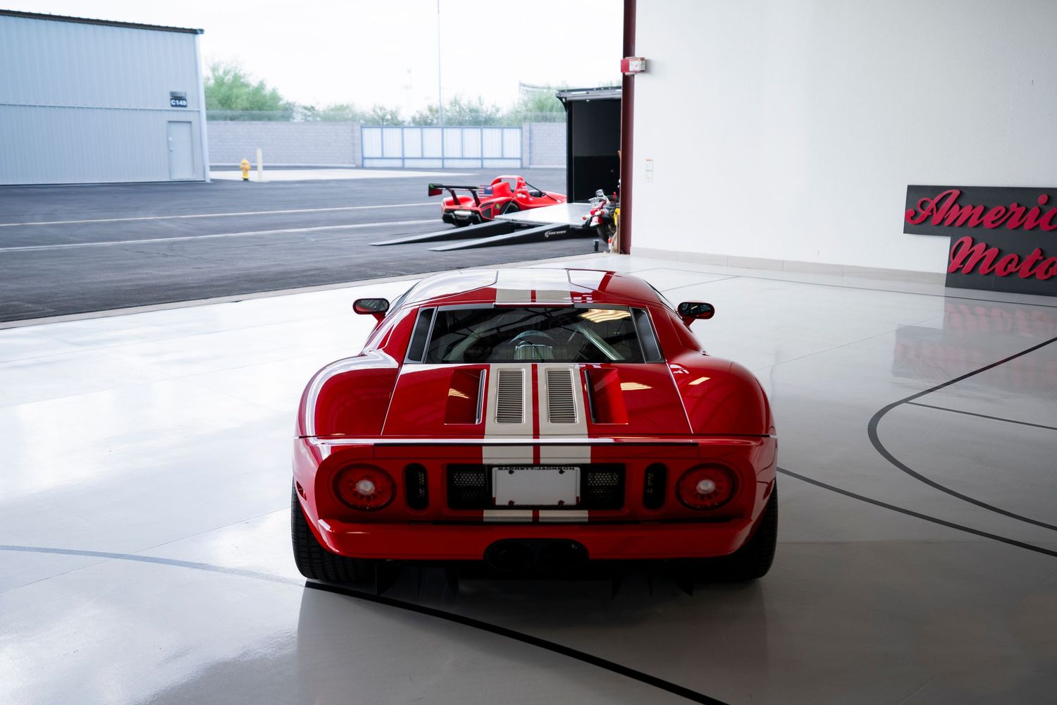 Rear view of a red Ford GT sports car in a white showroom.