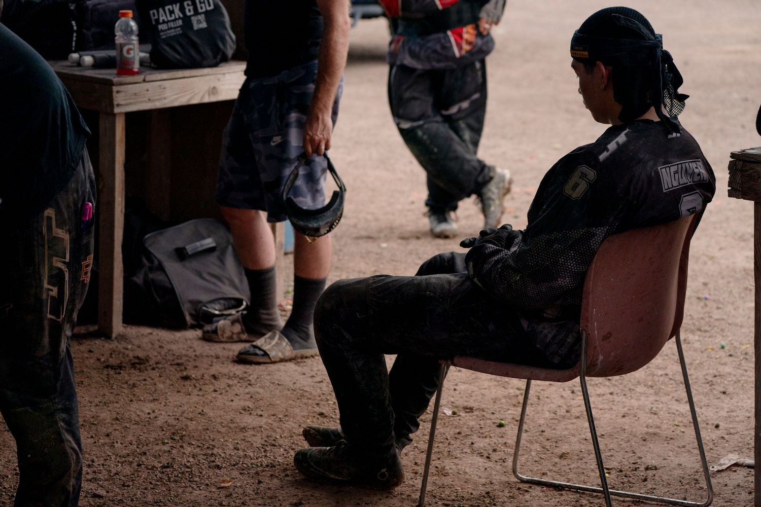 Players taking a break between paintball matches at rest area.
