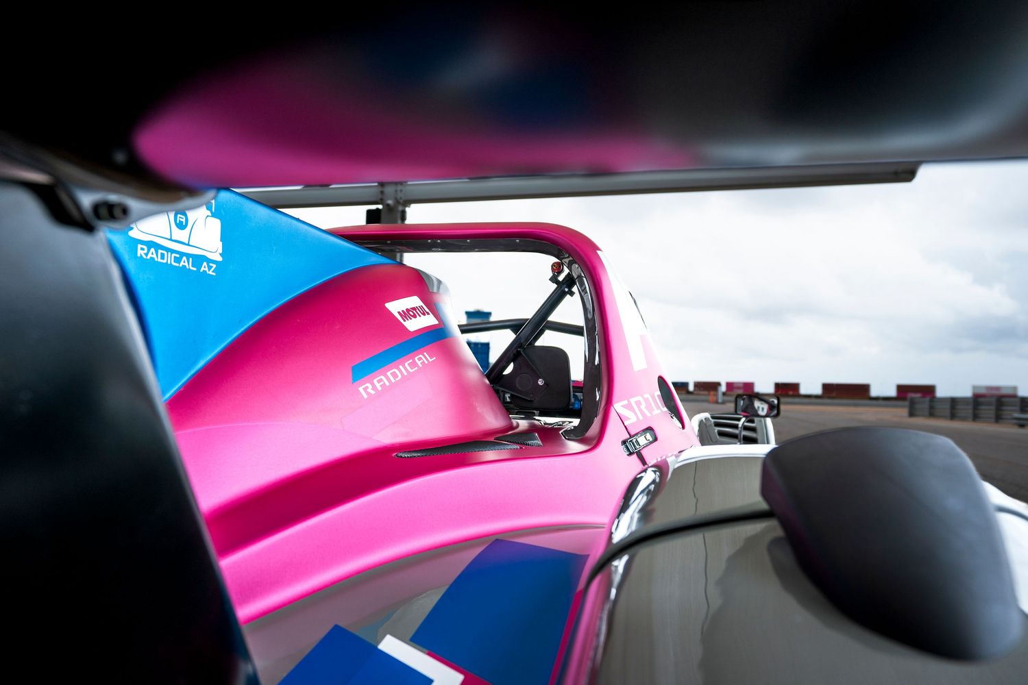 Close-up shots of motorcycle parts showing vibrant pink and blue paint details and chrome accents.