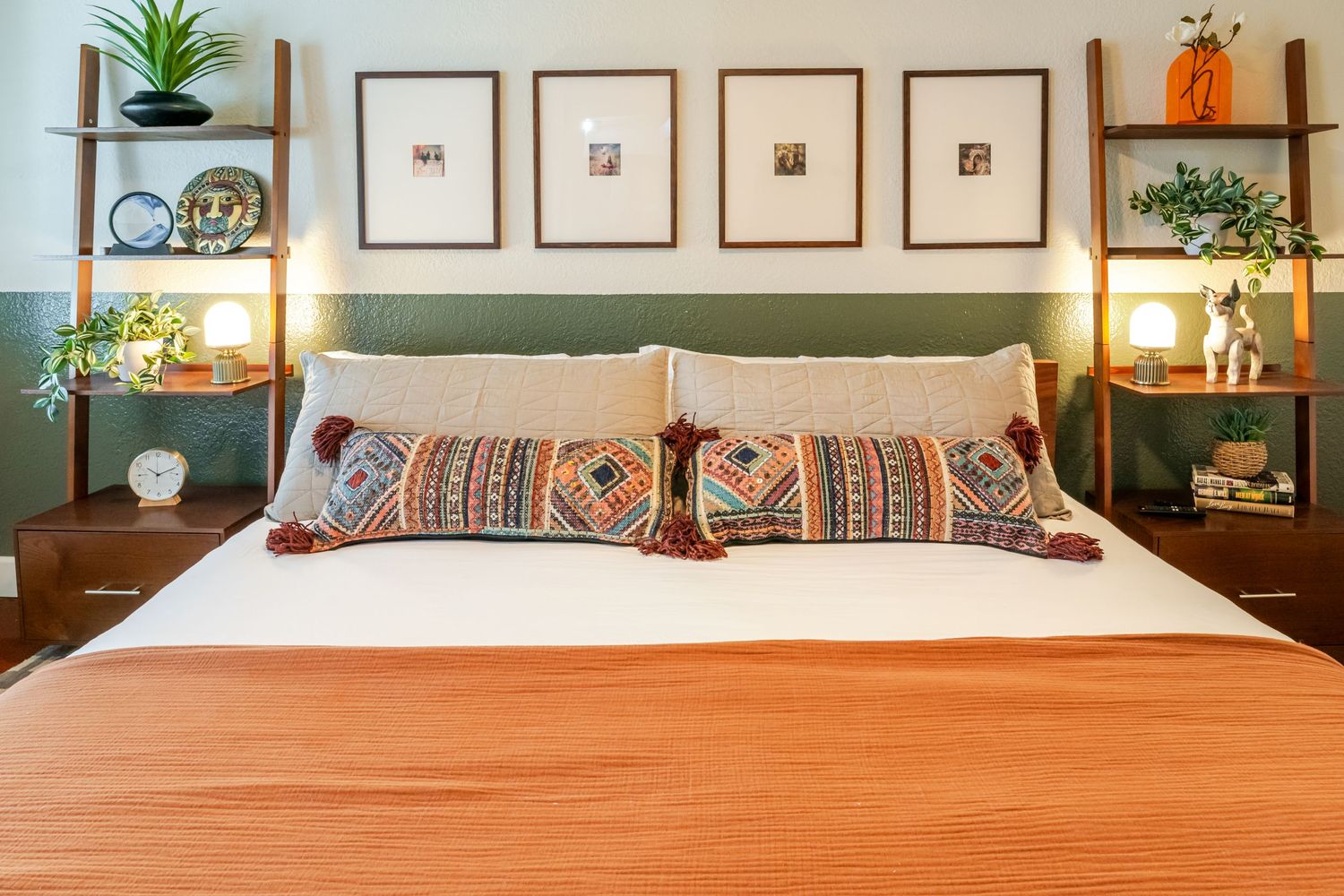 Modern bedroom interior with green headboard, wooden furniture, and decorative plants creating a cozy atmosphere.