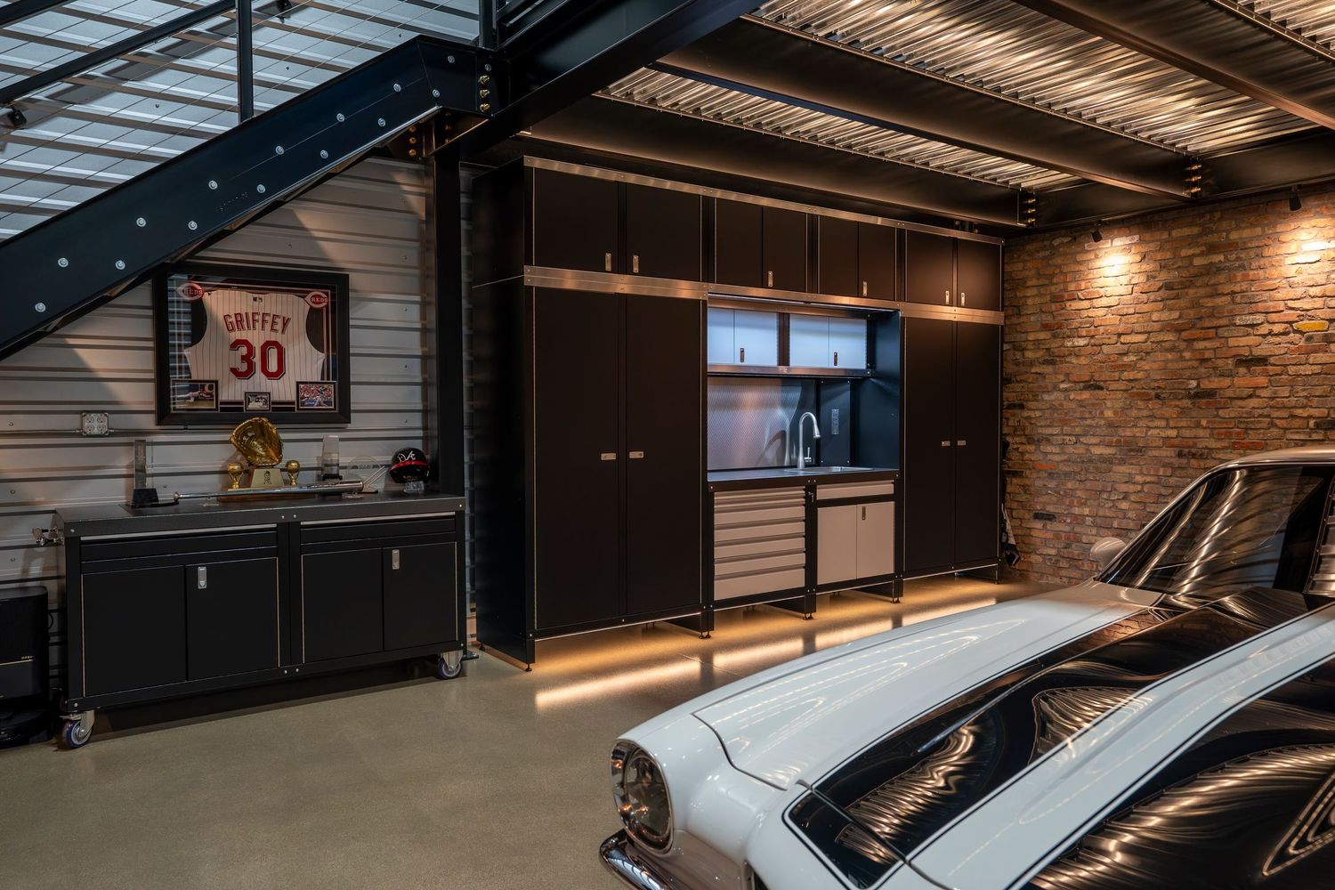 Large luxury garage space with polished concrete floors and industrial-style exposed ceiling.