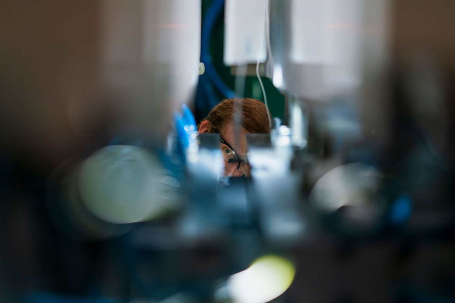 Person using a smartphone with blurred lights in the background creating a bokeh effect.
