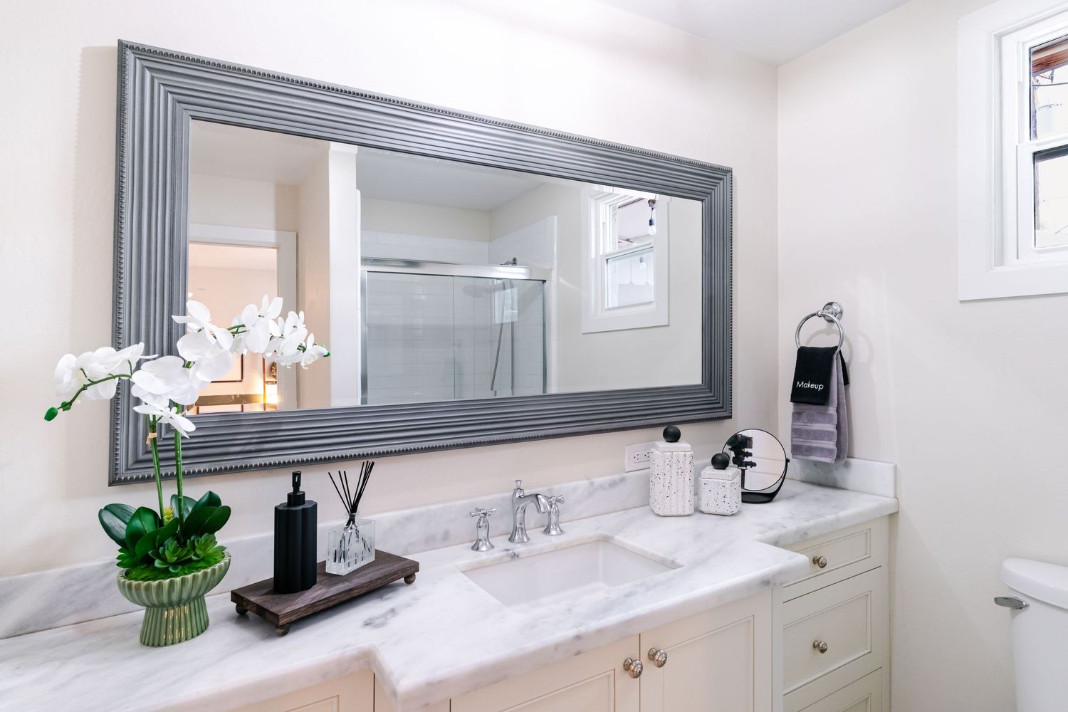 Clean white bathroom with modern fixtures, marble countertop, and minimalist design elements.