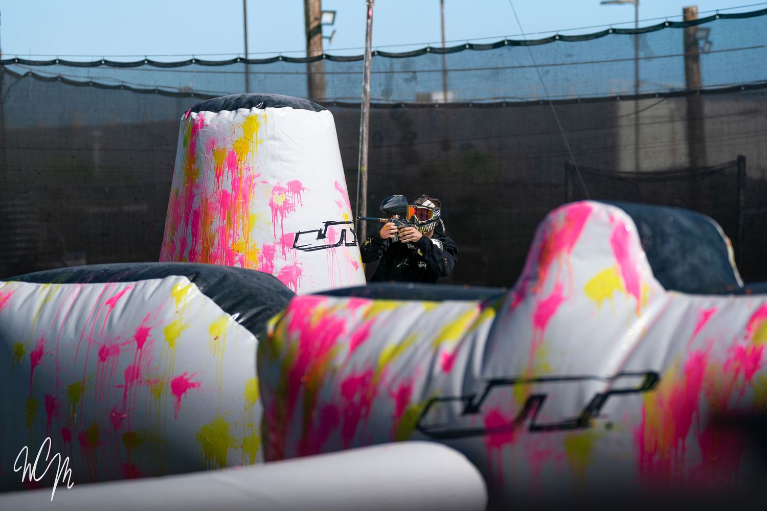 Colorful paintball bunkers with pink and yellow paint splatters during gameplay.