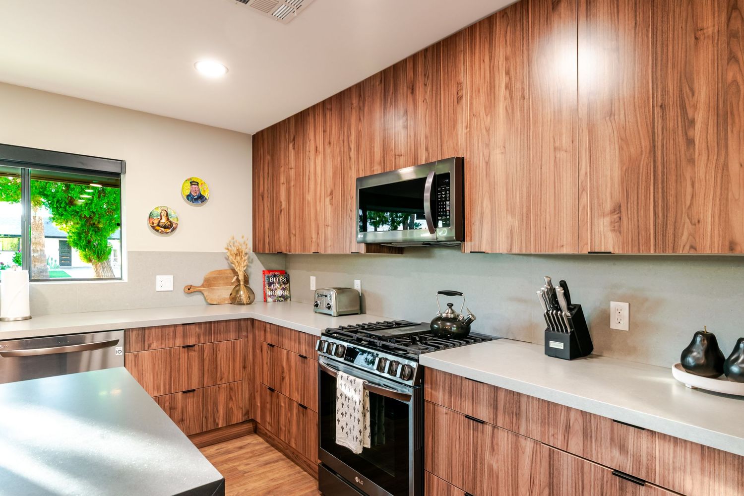 Contemporary kitchen with wood cabinets, white countertops and stainless steel appliances in an open layout design.