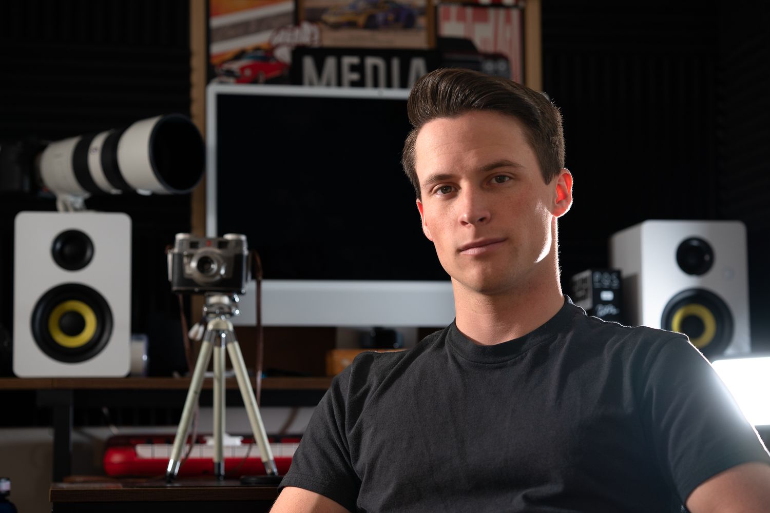Recording studio setup with professional audio equipment and camera on tripod.