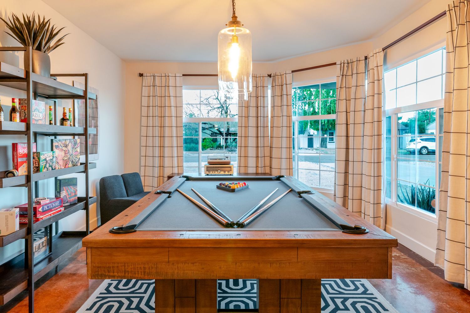 Game room with pool table, pendant lighting, and large windows with natural light.