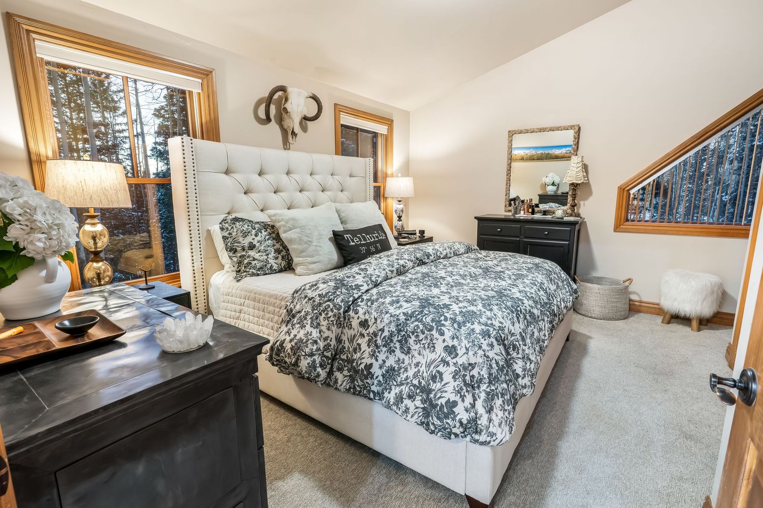 Elegant master bedroom with tufted headboard, blue and white bedding, and natural wood trim details.