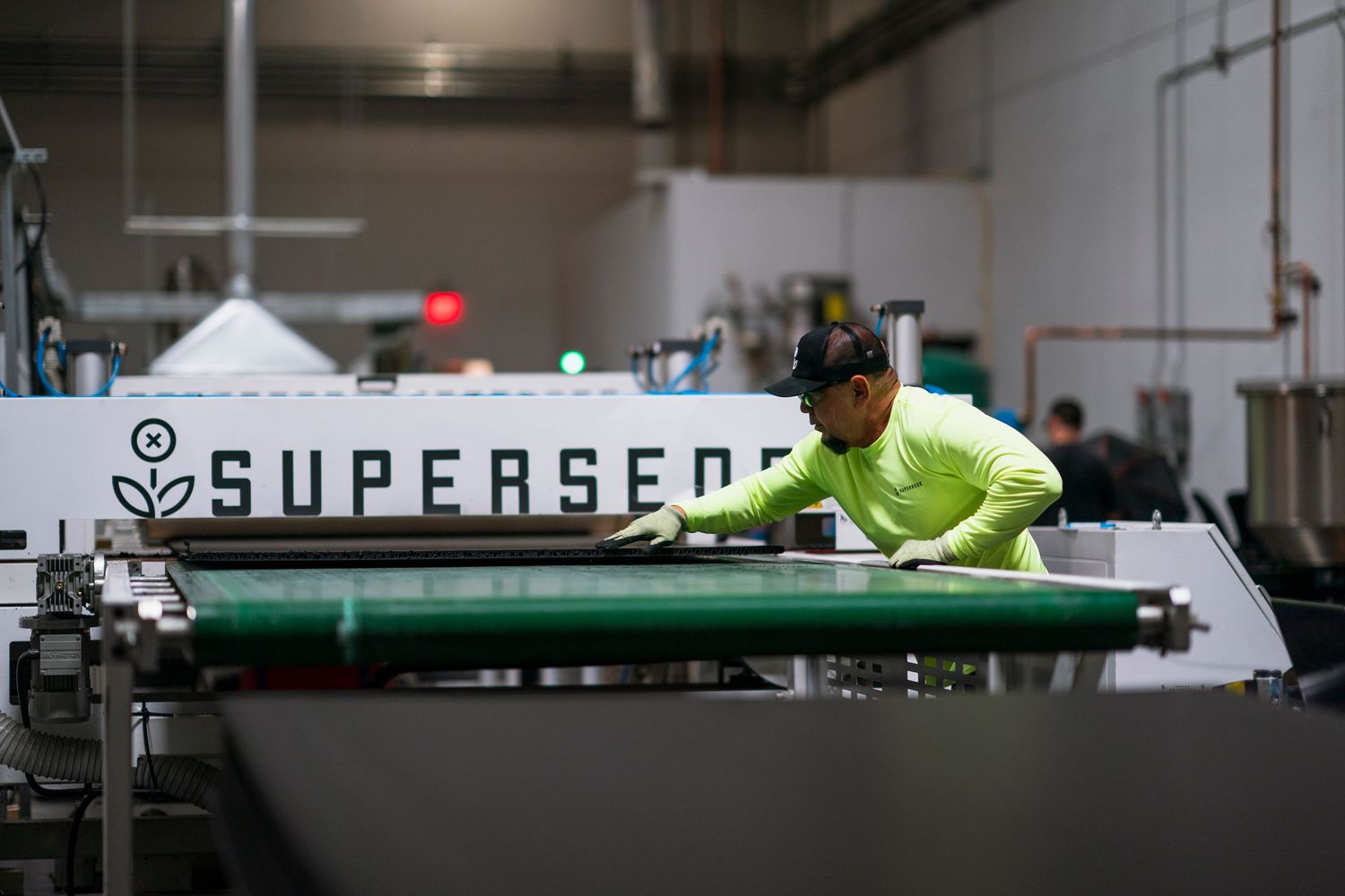 Manufacturing facility interior showing industrial equipment with Supersede signage.