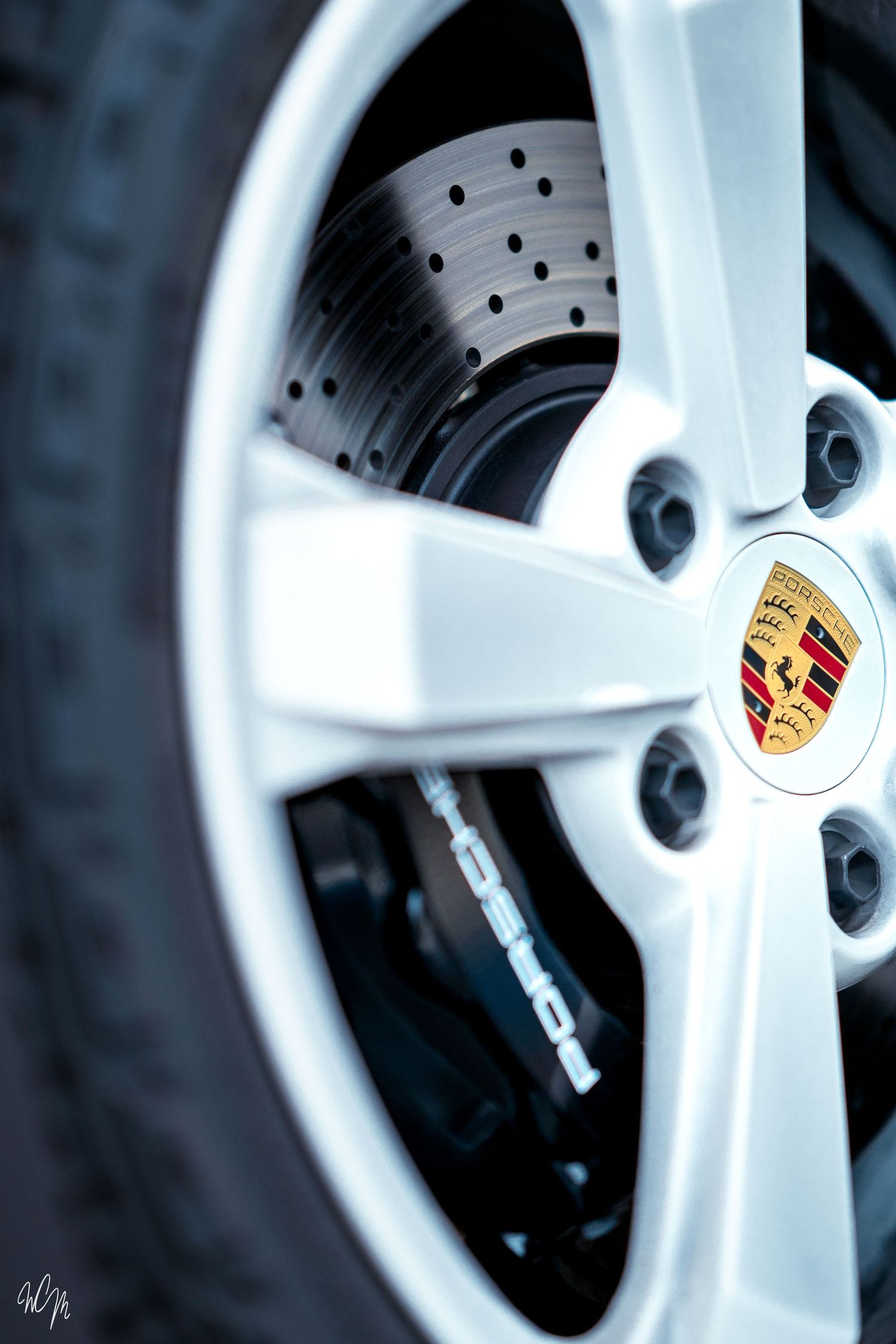 Close-up detail of a white Porsche wheel showing performance brake disc and caliper.