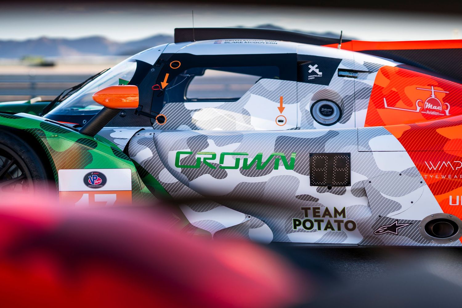 Artistic close-up of race car bodywork showing detailed sponsorship graphics and color schemes.