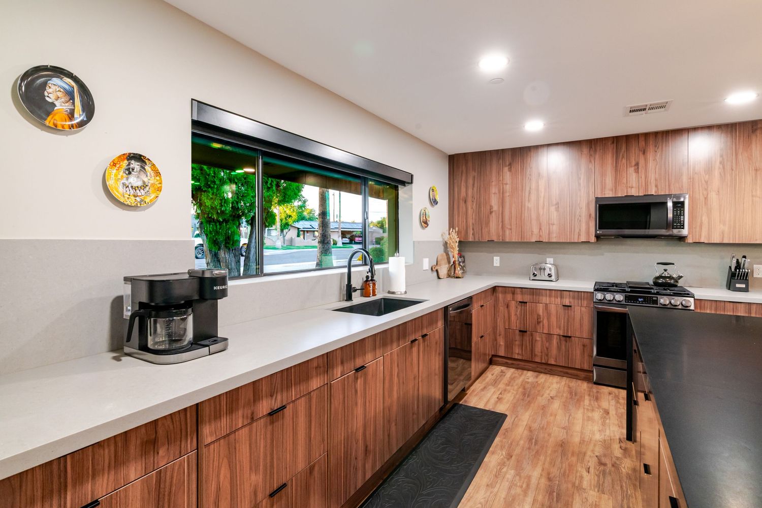 Modern kitchen features wood cabinets, recessed lighting, and sleek appliances in an open concept layout.