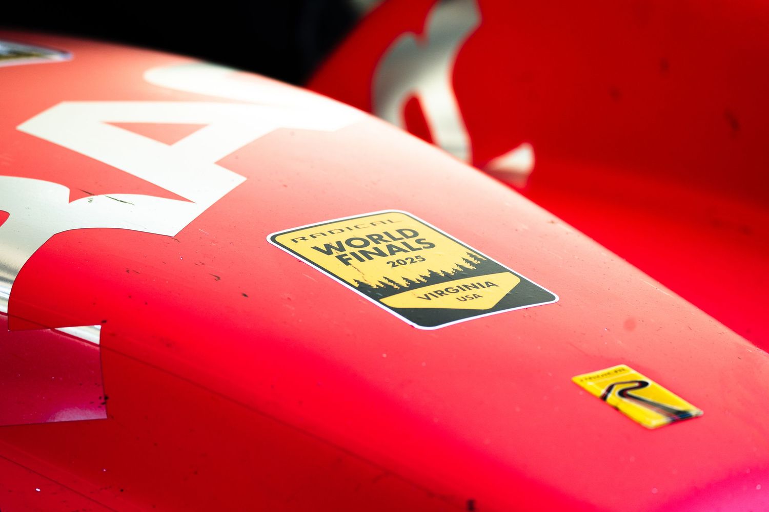 Red racing car bodywork with World Championship decal and sponsor logos.
