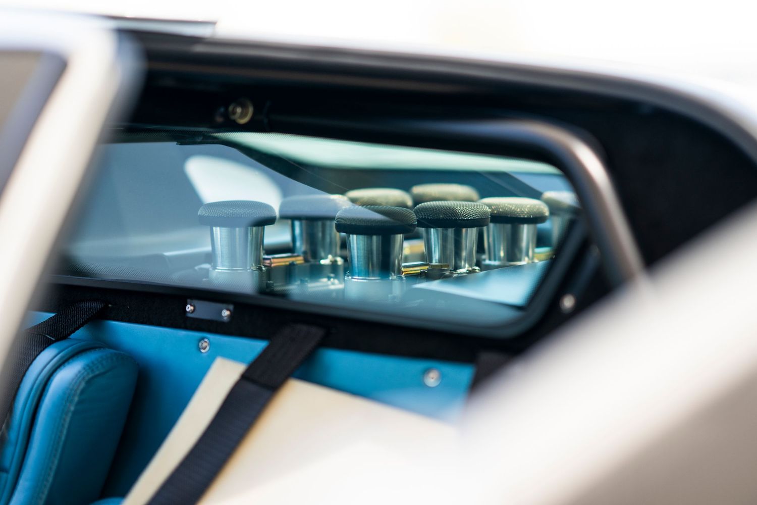Modern sports car interior detail showing dashboard and windshield with natural light streaming in.