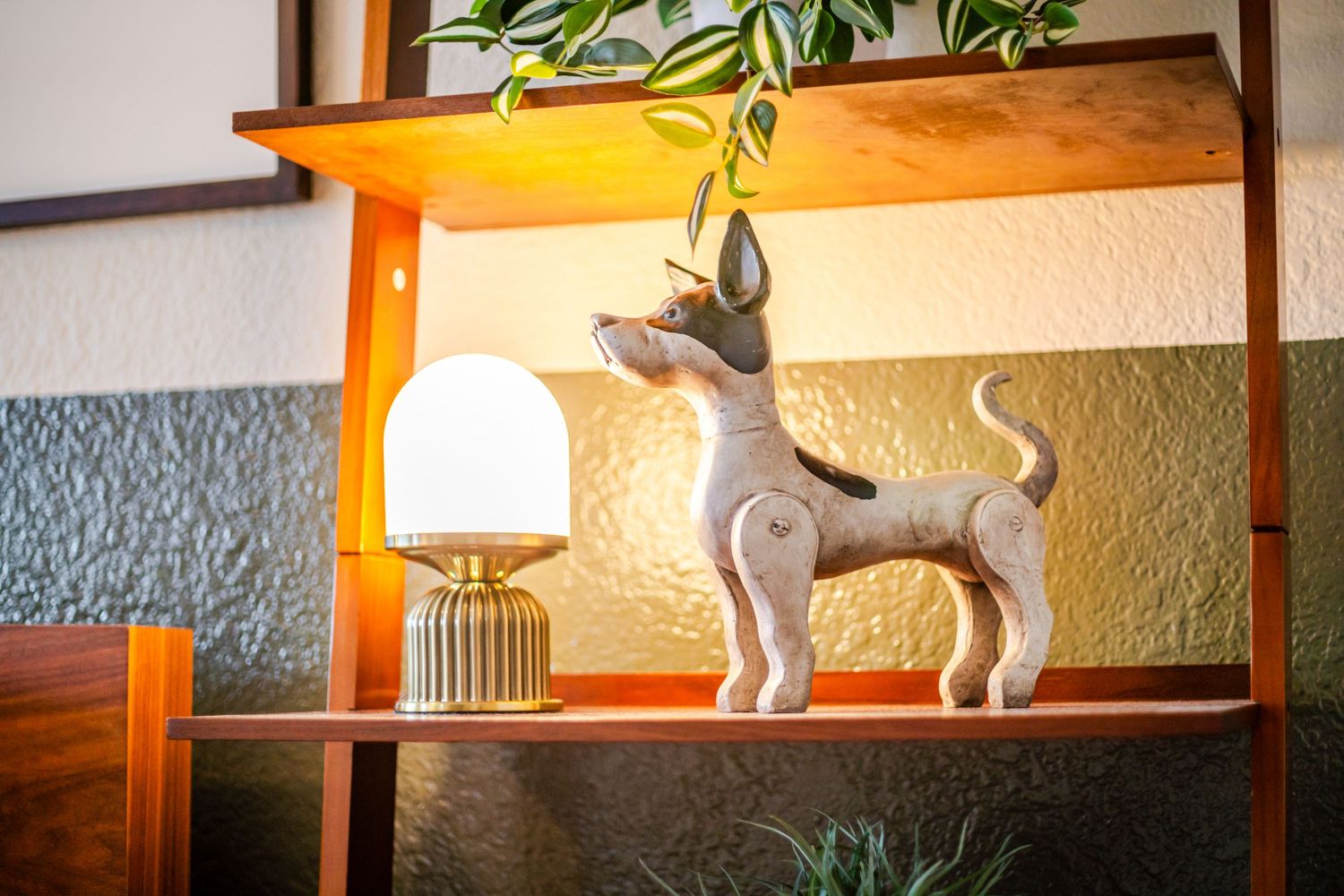 Decorative shelf display with ceramic animal figurines and modern lighting fixtures.