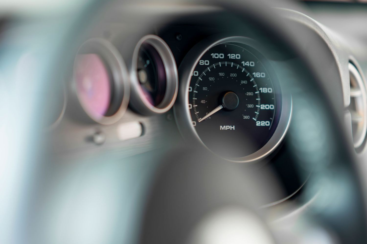Car dashboard display showing gauges and instrument cluster with illuminated indicators and dials.