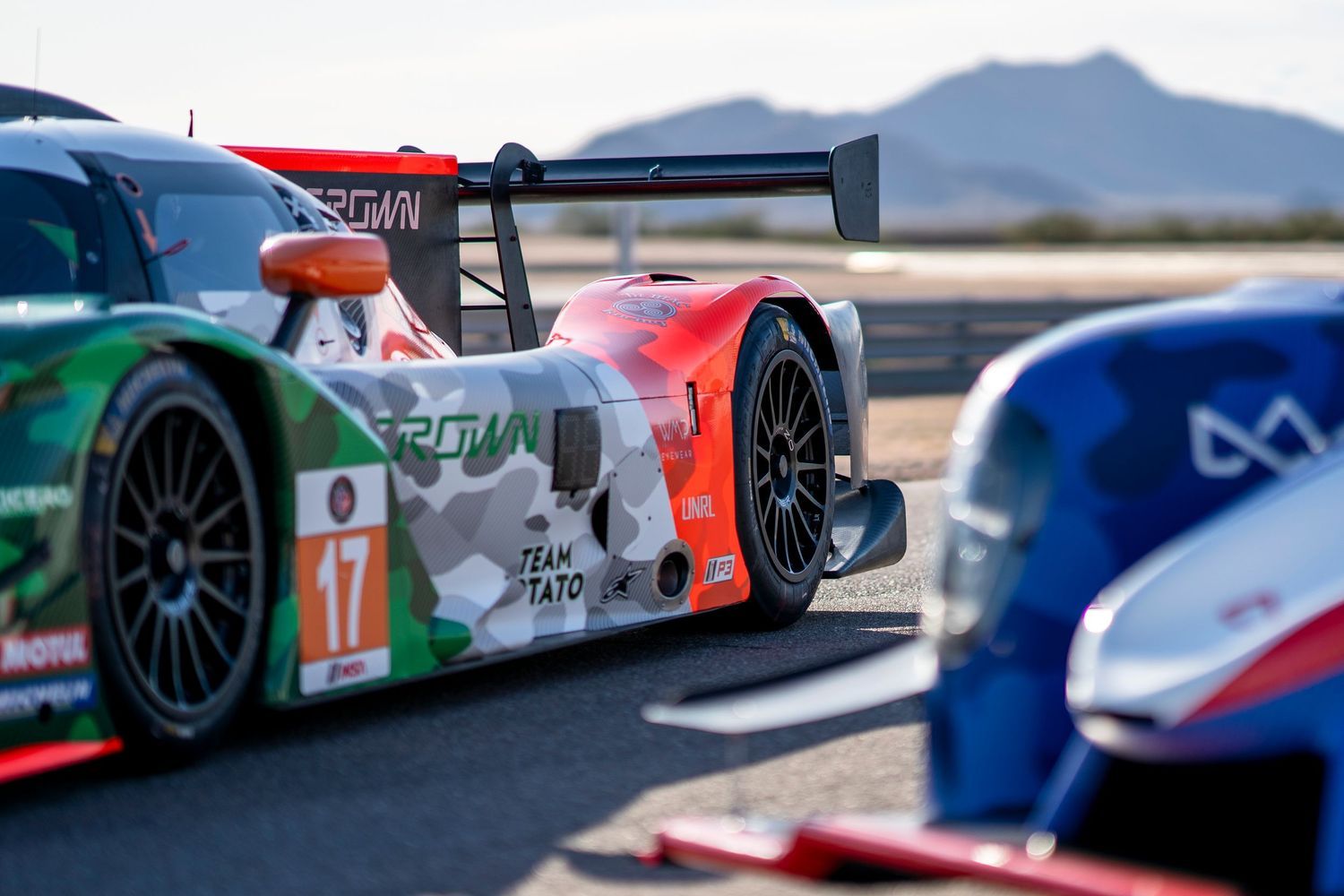 Side profile of a race car with Italian flag colors and prominent aerodynamic features.