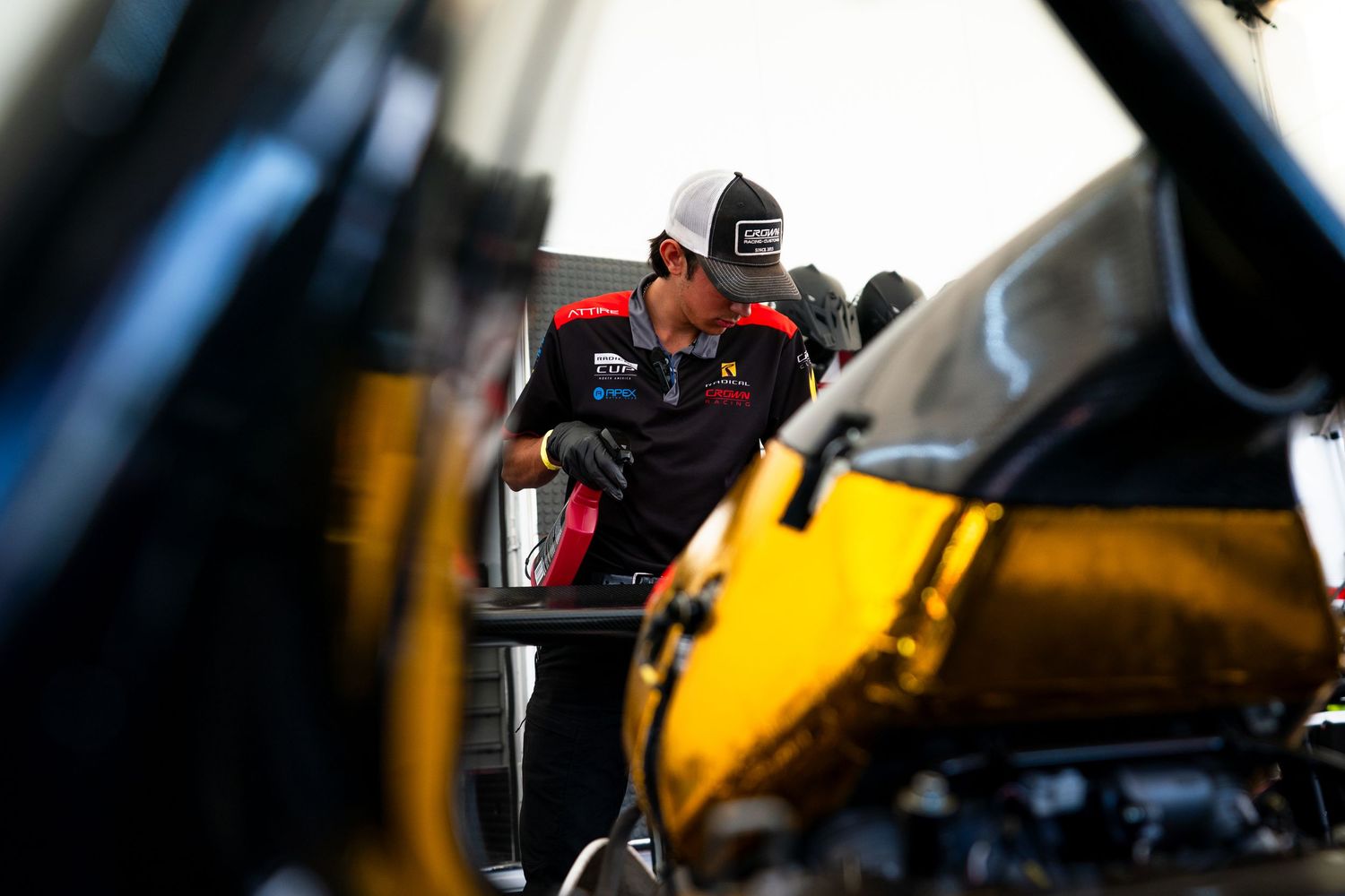 Close-up view of racing car components being inspected by team technicians.