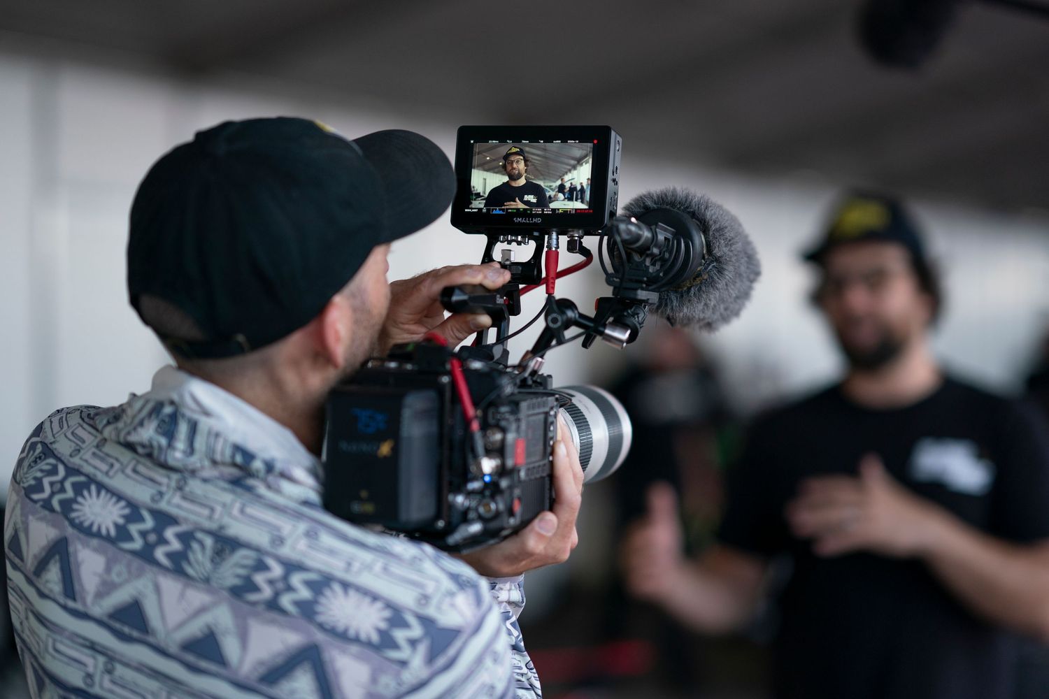 Camera operators and film crew members with professional equipment work together on a video production set.