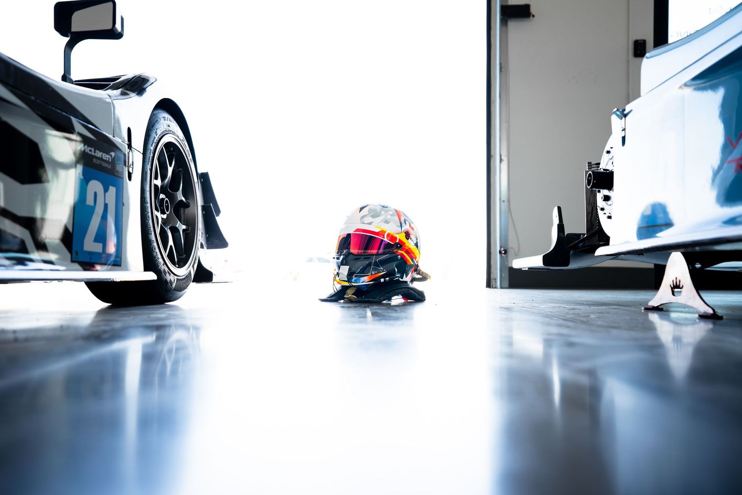 Low angle view of racing equipment and feet on polished concrete floor.